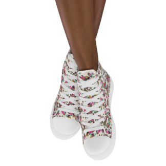 Paire de baskets hautes pour femme en toile imprimée “Léopard ivoire” semelles blanches de Paradis Perdus® portée par une femme vue de face jambes croisées dans le vide