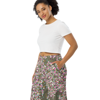 Pantalon large unisexe en coton imprimé “Léopard kaki” de Paradis Perdus® porté par une femme les mains dans les poches vue de profil